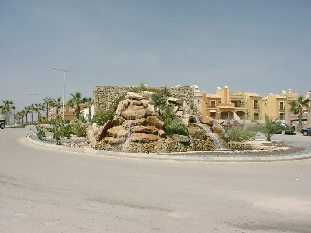 Rotonda con fuente moderna y palmeras en Algorfa