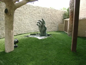 Jardín mediterráneo con fuente ornamental y césped en Orihuela Playa