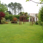 Amplio jardín privado con césped y pérgolas decorativas