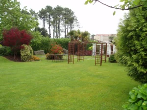 Amplio jardín privado con césped y pérgolas decorativas