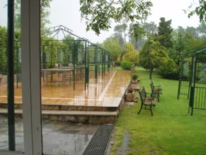 Terraza exterior con pérgolas y bancos junto al jardín