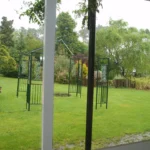 Zona ajardinada con estructura de pérgola y césped natural