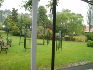 Zona ajardinada con estructura de pérgola y césped natural